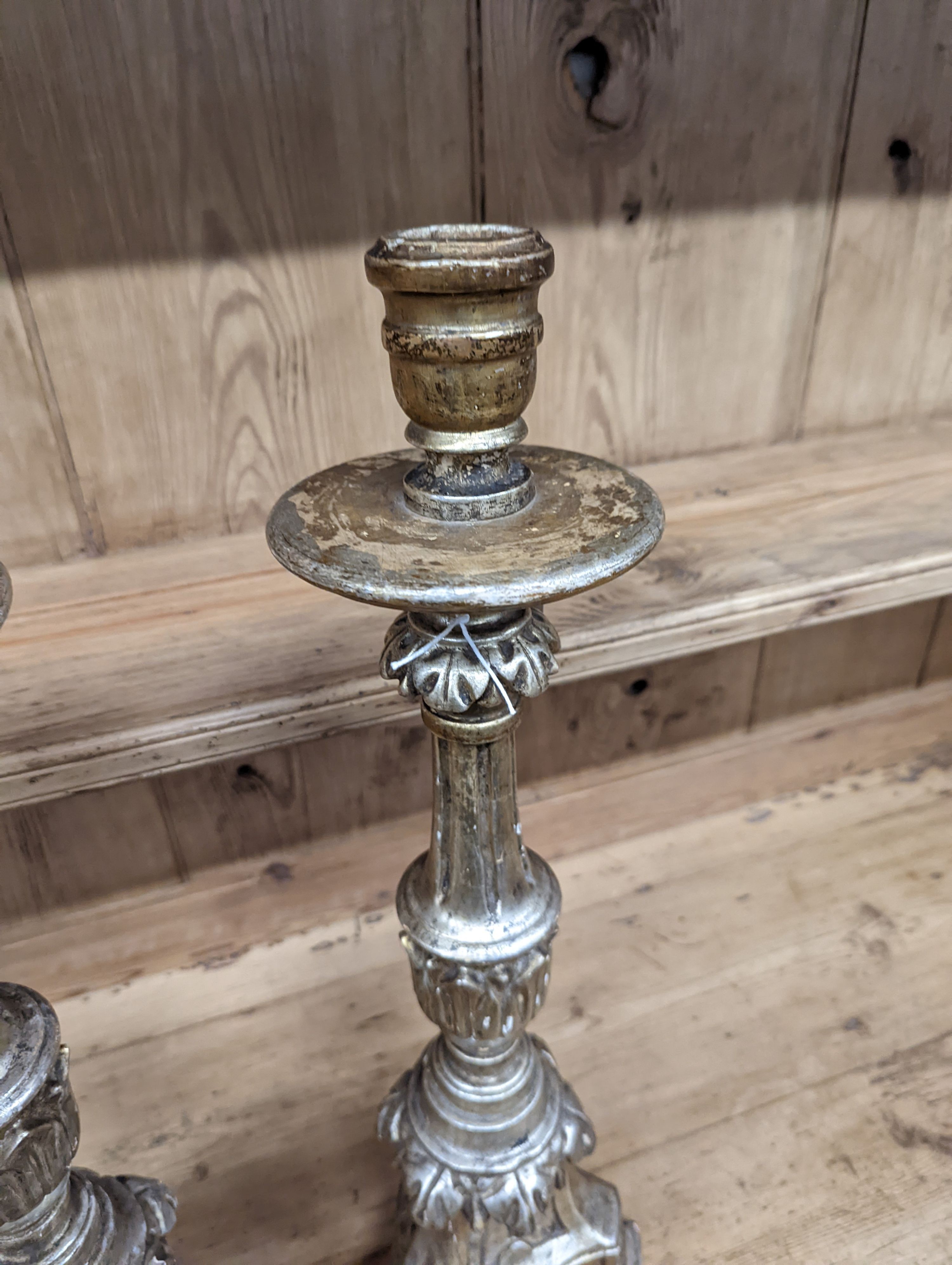 A pair of 18th century style carved silvered wood candlesticks, height 58cm